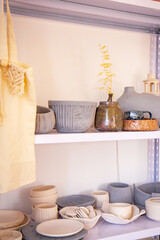 Handmade ceramic crockery and craft pottery. Inside interior of pottery. Racks in workshop in which there are many different pottery standing on the shelves in a potery workshop