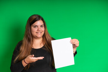 Fototapeta na wymiar Young woman holding a empty white paper, Green Background