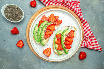 avocado toast with strawberries, soft cheese and chia seeds on a light background. healthy Breakfast or lunch. Keto diet. Food recipe background. Close up