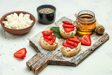 Crostini or toasts with strawberries and cream cheese ricotta. Delicious breakfast or snack, Clean eating, dieting, vegan food concept. top view