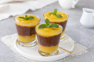 Overnight mango chocolate chia seed pudding or parfait. Selective focus, gray concrete background.