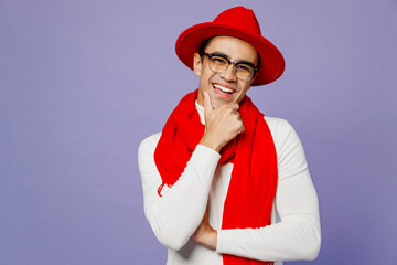 Young cheerful smiling fun middle eastern man 20s he wear white turtleneck red hat scarf eyeglasses prop up chin look camera isolated on plain pastel light purple background. People lifestyle concept.