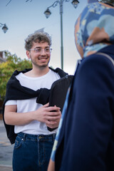 portrait of young man talking to his friend on the street