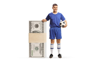 Man in a football jersey standing next to a big stack of money