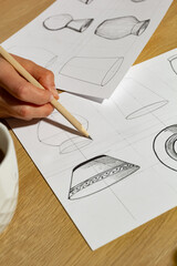 The designer draws sketches of kitchen utensils.