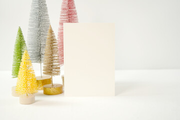 Christmas holiday greeting card, party invitation mockup styled with minimalist pastel Scandi Christmas trees against a white background.