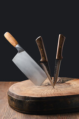 Cleaver and knives stick in wooden blockhead