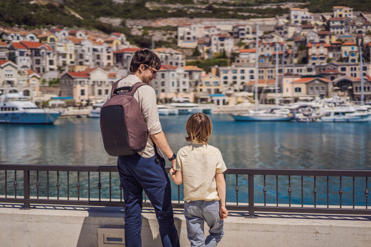 Father and son tourists enjoying the views of Architecture and luxury yachts in Lustica Bay, Montenegro. Travel around Montenegro concept. Go Everywhere