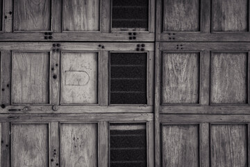 Old wooden door with square repetition modules, space for text, horizontal image.