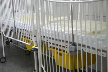 Weiße Patientenbetten für Kinder mit hochgezogenem Gitter in Krankenhaus 