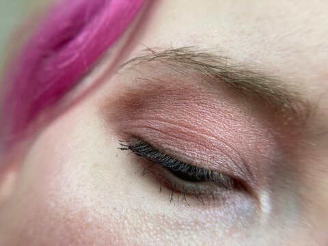 Pink eye shadow. Eyelashes close-up. Macro photo of eye makeup in red tones