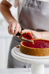 The confectioner cut off a piece of cake for tasting. Berry pie. High quality photo