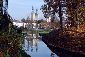 Fototapeta na wymiar Zbaszyn, Poland - a cityscape view with a canal leading to a marina in the city center and baroque Saint Mary church in the background