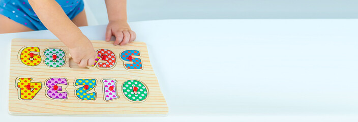 The child learns numbers at the table. Selective focus.