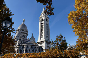 Fototapeta premium The famous basilica Sacre Coeur with autumnal trees , Paris, France.