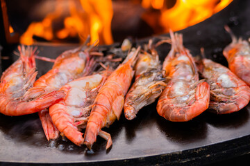 Process of cooking fresh red langoustine shrimps, prawns on grill at summer local food market - close up. Outdoor cooking, barbecue, gastronomy, seafood, cookery and street food concept