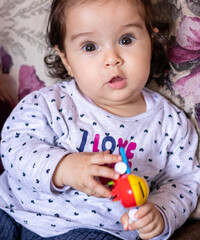 little cute baby grinning and playing with toys at home, on carpet