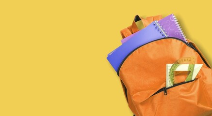 School Backpack on yellow background. School education concept.