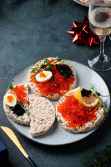 New Year and Merry Christmas concept. tartlets with red caviar, champagne and christmas decor. Rice cake with caviar. Christmas appetizer