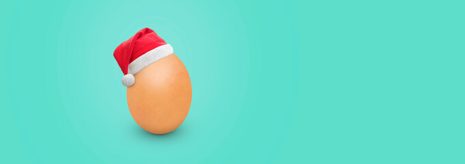 egg with santa claus hat at christmas on blue background