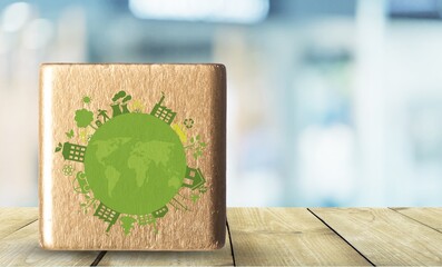 Eco friendly wooden cube with green globe icon.