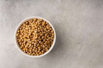 A bowl of raw chickpeas on a light background