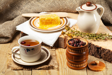 cup of herbal tea and ingredients on wooden table