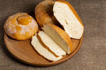 homemade wheels of cheese on wooden table.
