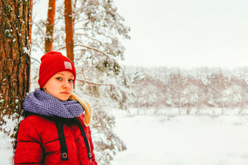 a girl in a red jacket is standing in the forest laughing in winter against the backdrop of a snowy...