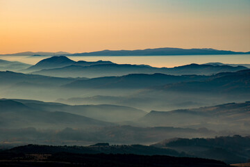 Sunrise in mountains with fog in valleys