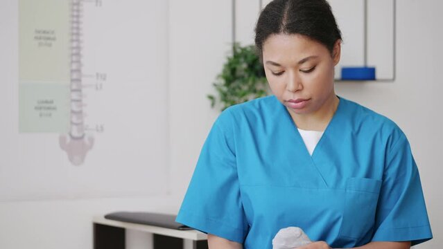 Woman physiatrist gently massaging patient's foot, rehabilitation after surgery
