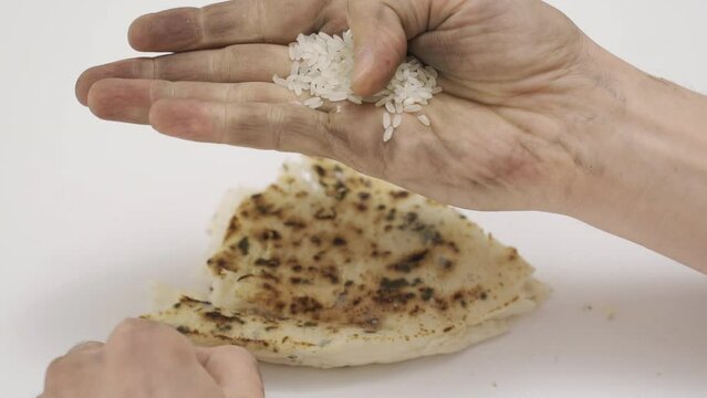 Hunger crisis. Hungry poor male hand holding rice grains and moldy bread.
Hunger crisis and rising food prices and food shortages.
