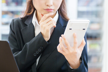 電卓を持って考える女性