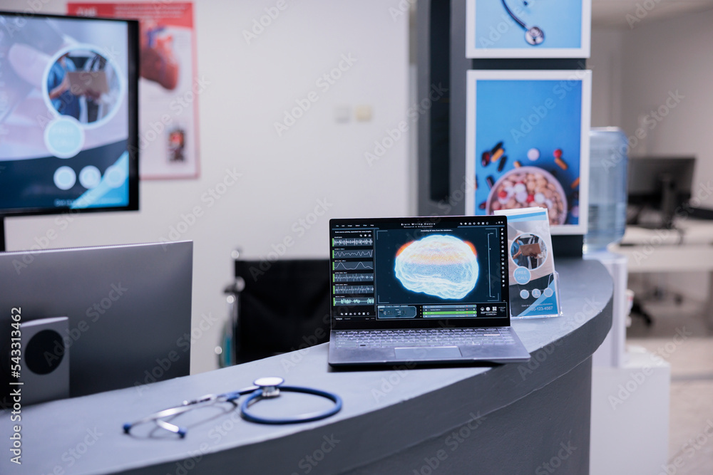 Poster brain scan displayed on laptop screen on doctor office desk. computerized tomography images showing 