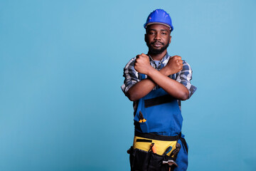 Builder making gesture of declining crossed arms while looking at camera. African american...