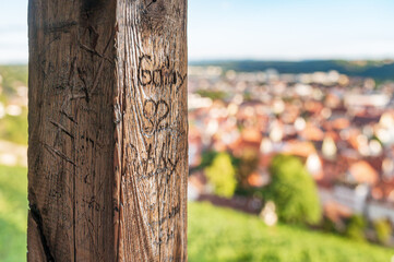 Eingeritzte Namen im Holzbalken der Burg Esslingen mit Panorama über die Stadt im Hintergrund