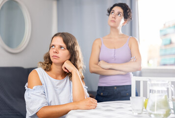 Stressed young LGBTQ female couple feeling offended after quarrel at home
