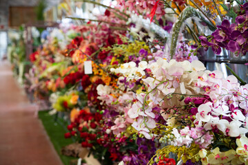 Colorful showcase of flower shop with large assortment of artificial flowers