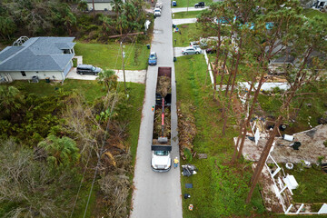 Top view of Hurricane Ian special aftermath recovery dump truck picking up tree branches debris...