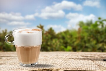 Tasty coffee in a cup on beautiful natural background