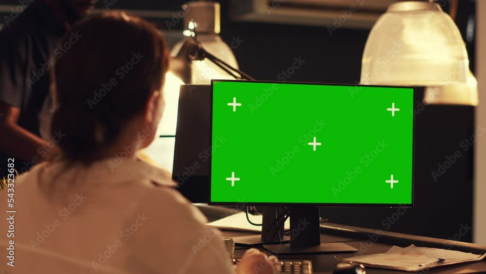 Poster woman working with greenscreen template on computer, looking at blank mockup background. analyzing s
