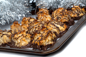 Homemade cookies with coconut on baking tray. Chocolate drizzled coconut macaroons , selective focus. Christmas cookies 