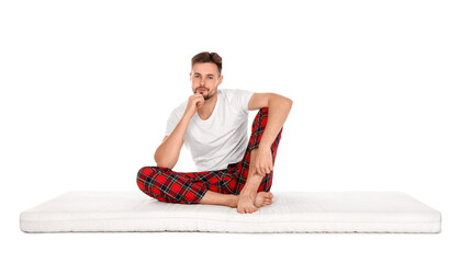 Fototapeta premium Man sitting on soft mattress against white background