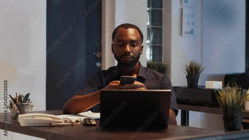 Poster portrait of smiling disruptive employee texting messages on smartphone, using internet app and worki
