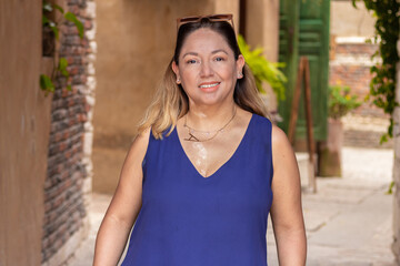 Latina morena en callejon del pueblo posando muy feliz