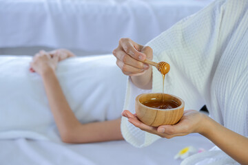 Honey dripping, pouring from honey dipper at spa