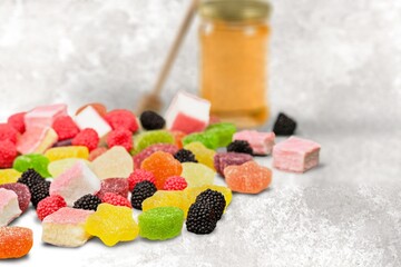 Tasty gummy candy surrounding a jar of hemp oil