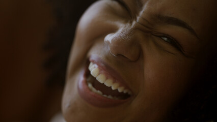 Black woman laughing at a joke on mobile phone