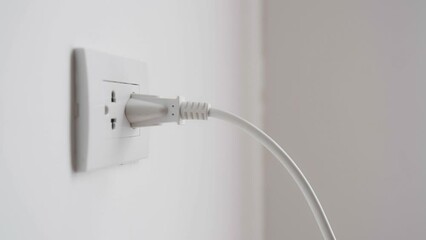 Close up of hand plugging in power cord and unplugging into socket to save energy, Reduce energy efficiency