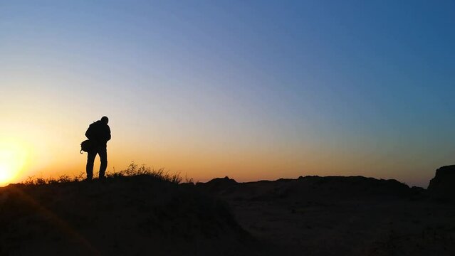 The photographer is silhouetted at sunrise